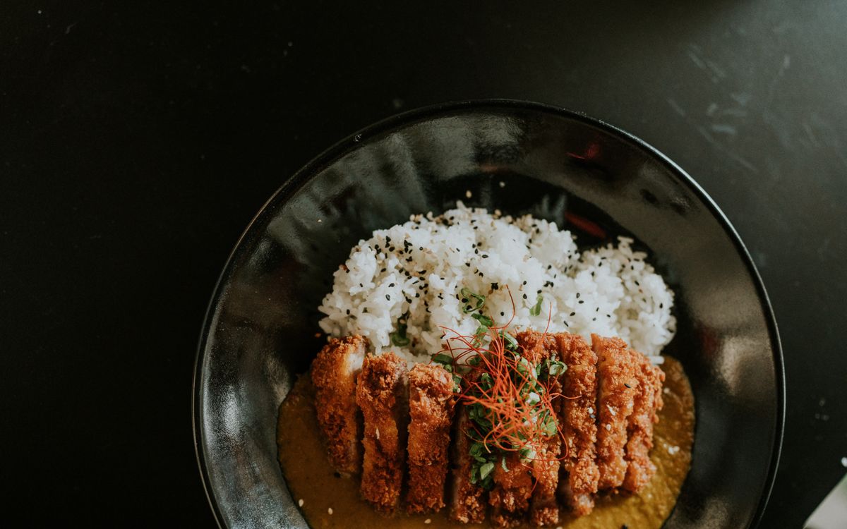 Sliced crispy breaded chicken cutlet served with rice