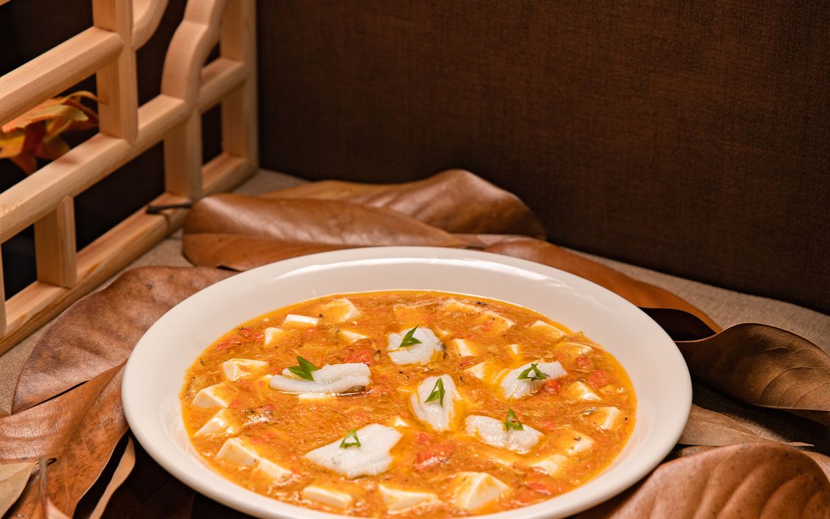 Tofu cubes in a spicy red sauce served in a white bowl