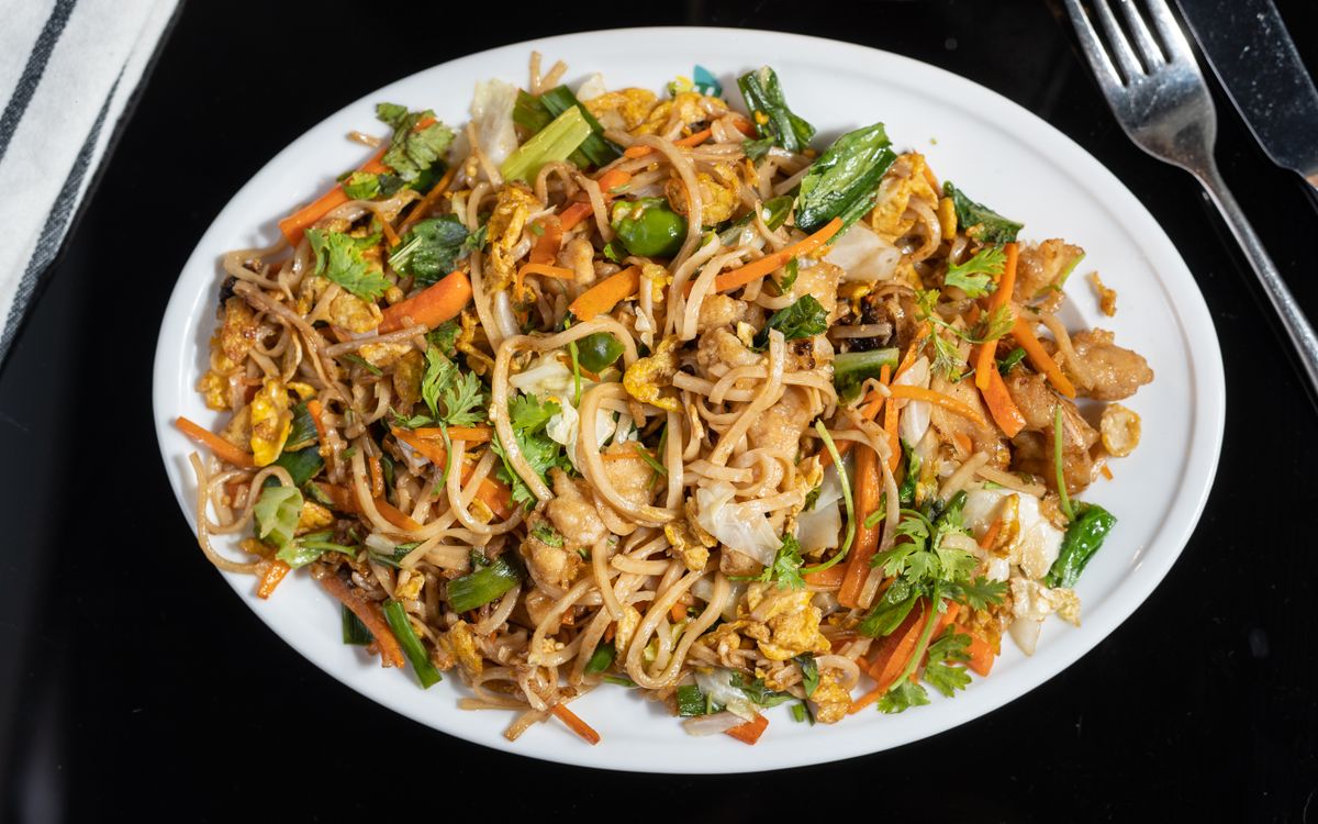A plate of stir-fried noodles with vegetables