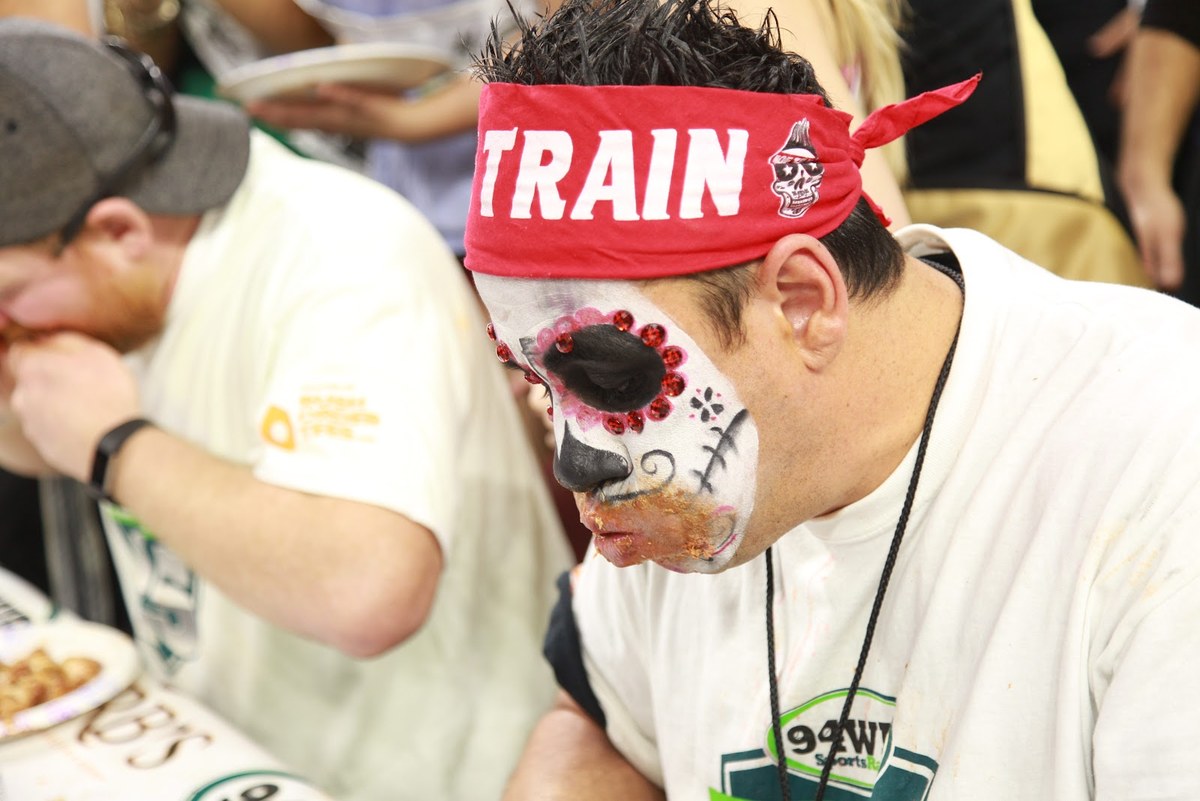 Close-up of Moe Train at Wing Bowl 25, red MOE TRAIN headband and skull face paint, sauce on his chin mid-contest