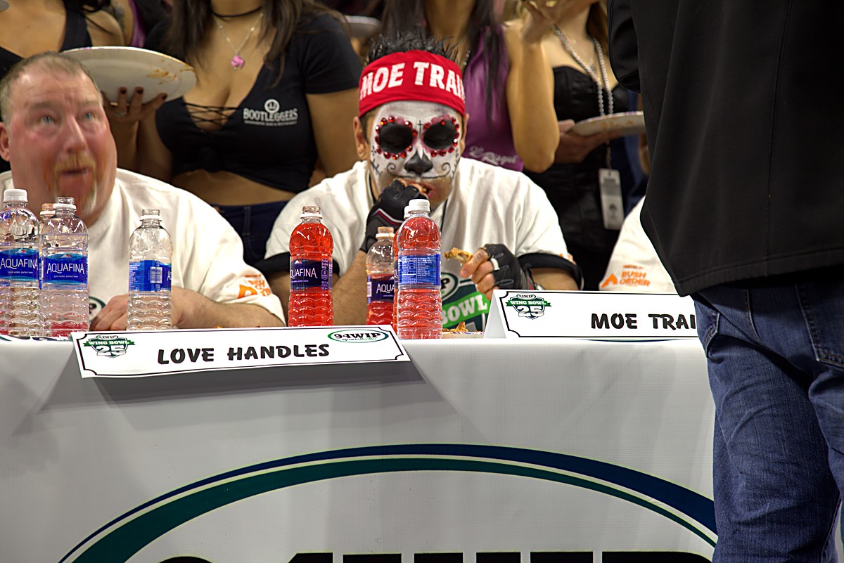 Eaters at the competition table with water bottles and name plates at Wing Bowl 25