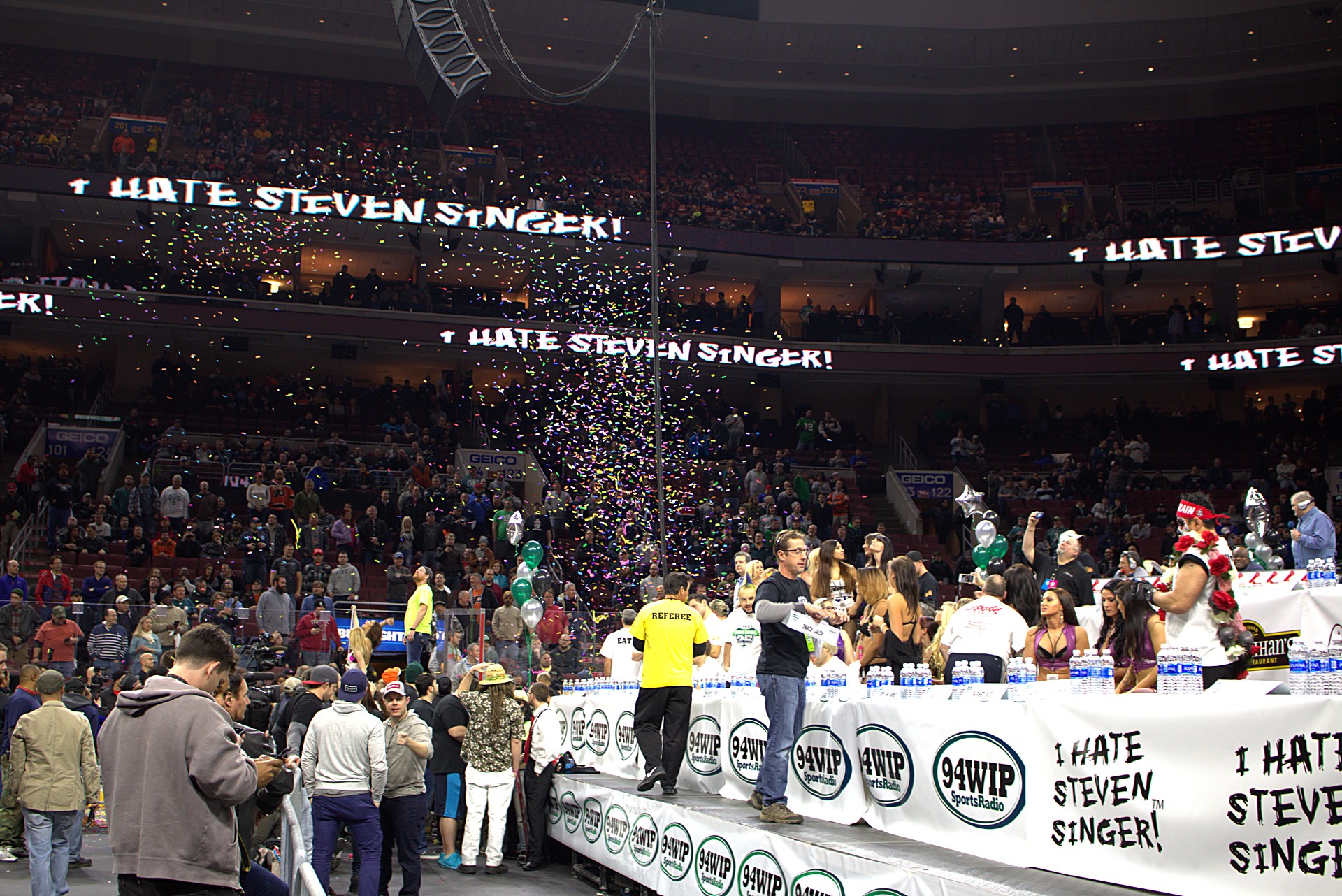 Confetti falling over a packed arena crowd and the long competition table at Wing Bowl 25